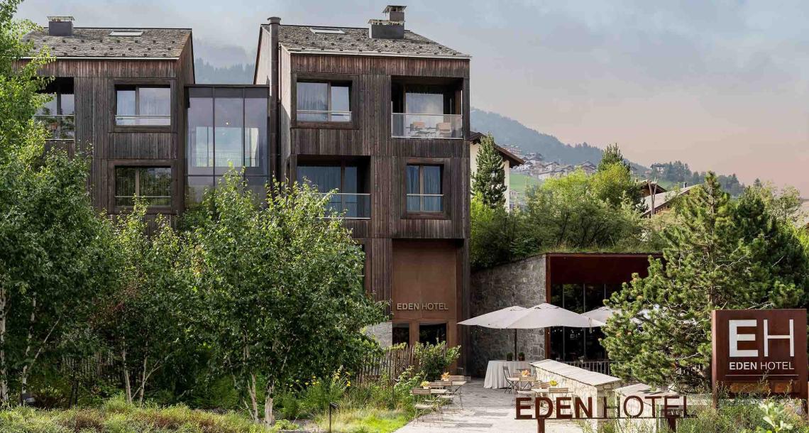 Hotel Eden immerso nel verde, con strutture in legno e terrazza all'aperto.