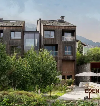 Hotel moderno immerso nel verde con vista montagna e terrazza esterna.