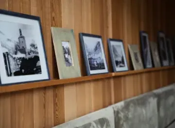 Cornici con foto in bianco e nero su mensola di legno.